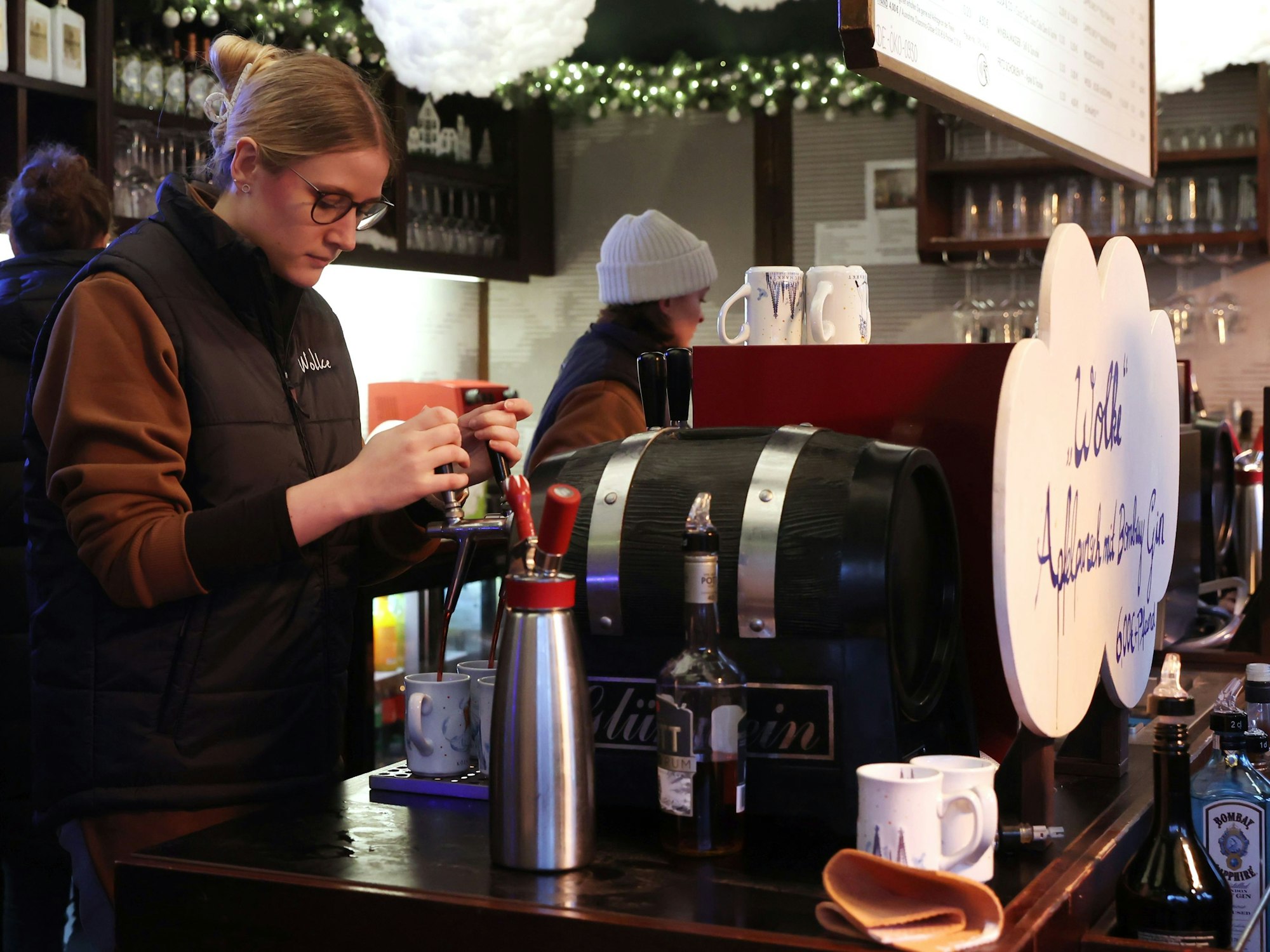 Annika Müller zapft mit beiden Händen Glühwein.