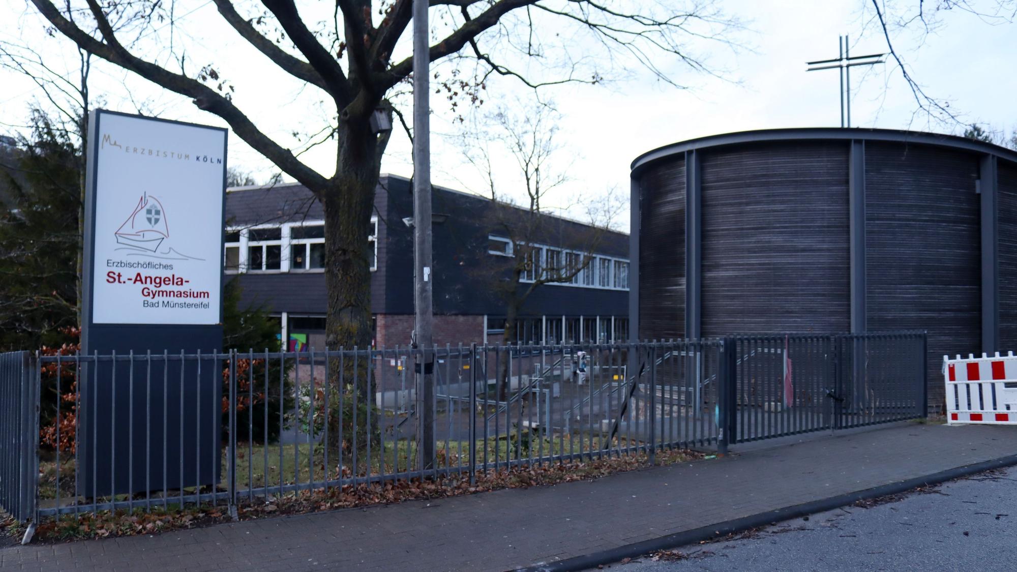 Die Außenansicht des St.-Angela-Gymnasiums vom Haupteingang aus. Rechts die Kapelle, links das neue Schild.
