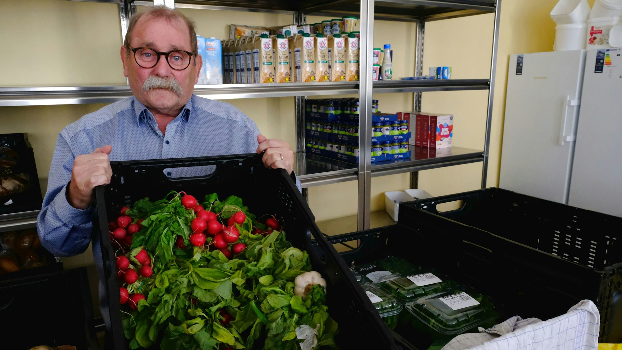 Wolfgang Weilerswist mit einer Gemüsekiste voller Radieschen in den Räumen der Mechernicher Tafel.