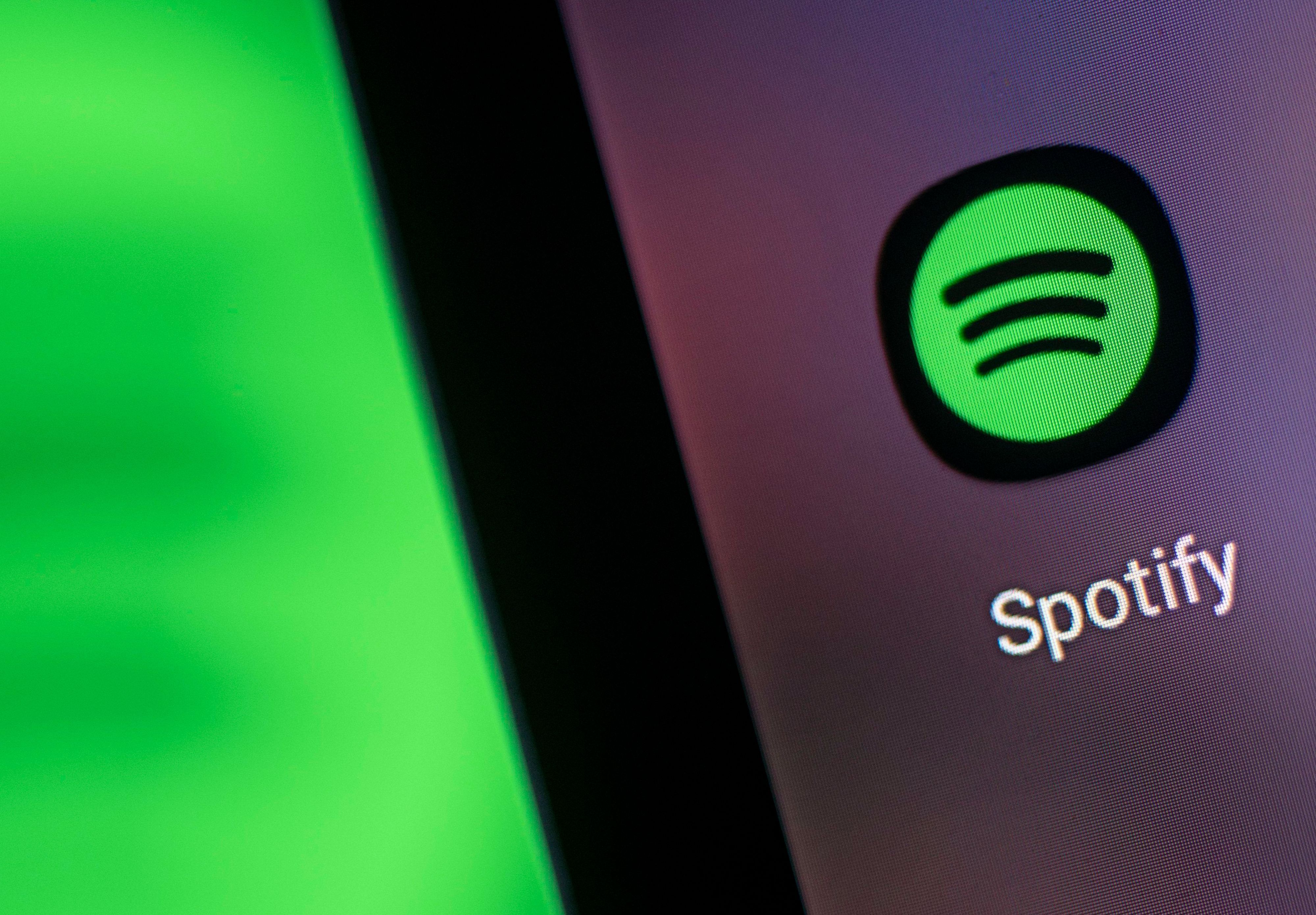 Auf dem Bildschirm eines Smartphones sieht man das Logo der App Spotify.