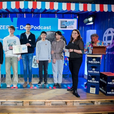 Einen Preis gab es für den Podcast „Beyond Zero“, Lehrer Marc Büssing vom Gymnasium Frechen nahm den Preis mit seinen Schülerinnen und Schülern entgegen. Jurorin Alexandra Habicher (2. von r.) las die Würdigung der Jury vor.