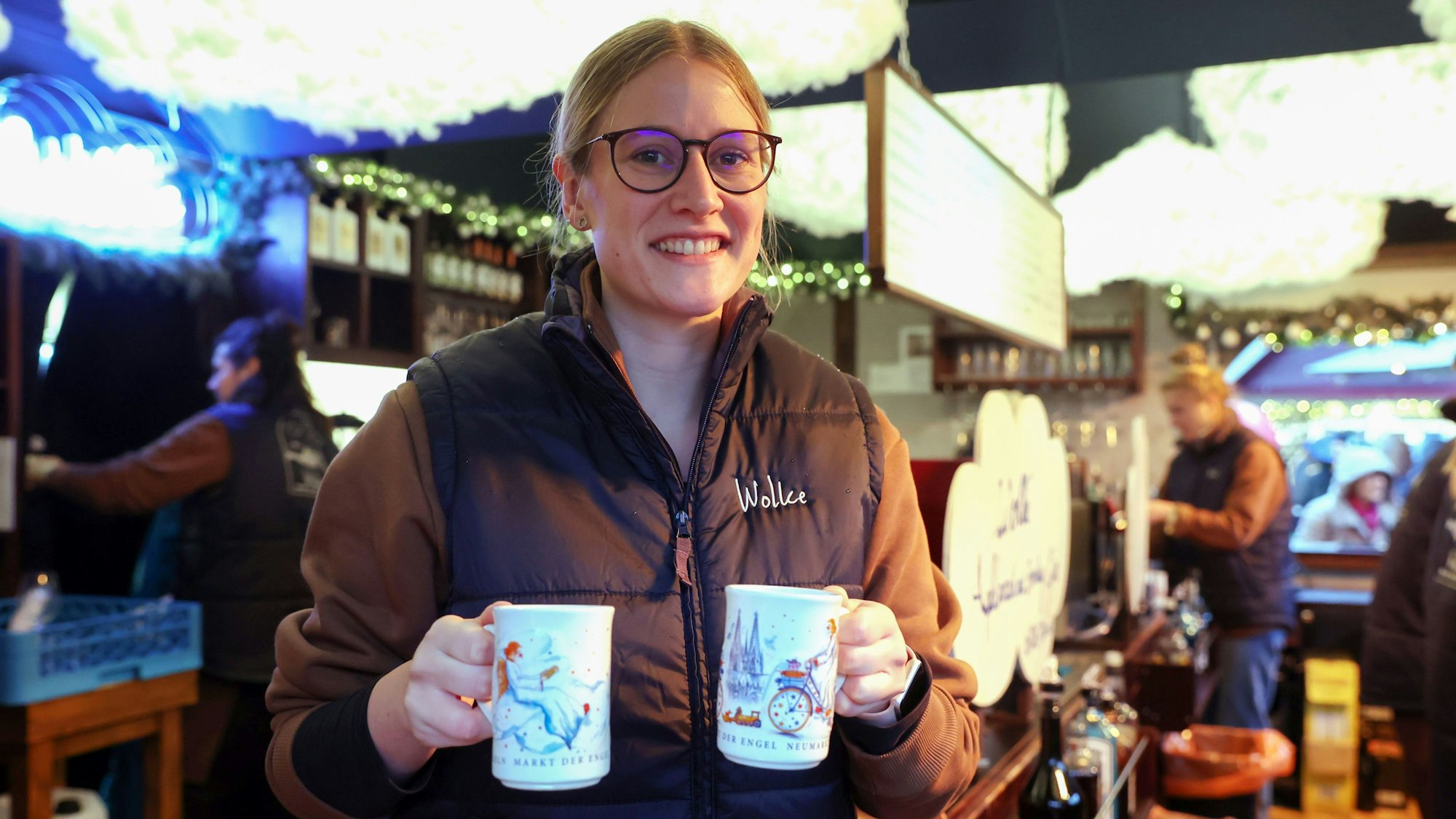 Annika Müller hält zwei Tassen Glühwein in der Hand.