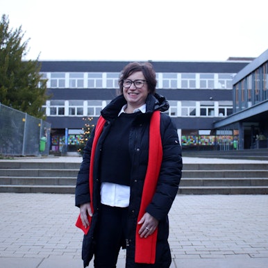 Alexandra Kühne, stellvertretende Vorsitzende der Schulpflegschaft, steht lächelnd auf dem Schulhof des St.-Angela-Gymnasiums.