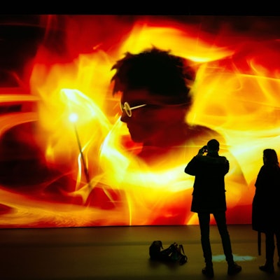 Auf einer Leinwand ist der Schatten von Harry Potter in roten Farbwirbeln zu sehen.