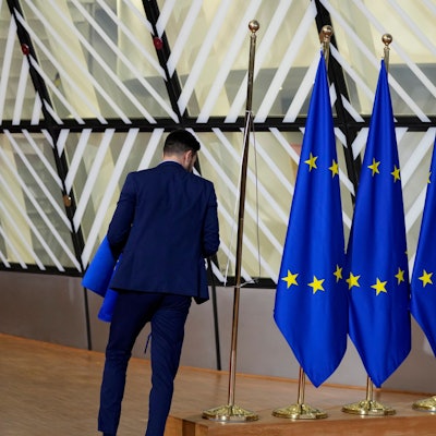 Ein Mann betrachtet drei EU-Flaggen