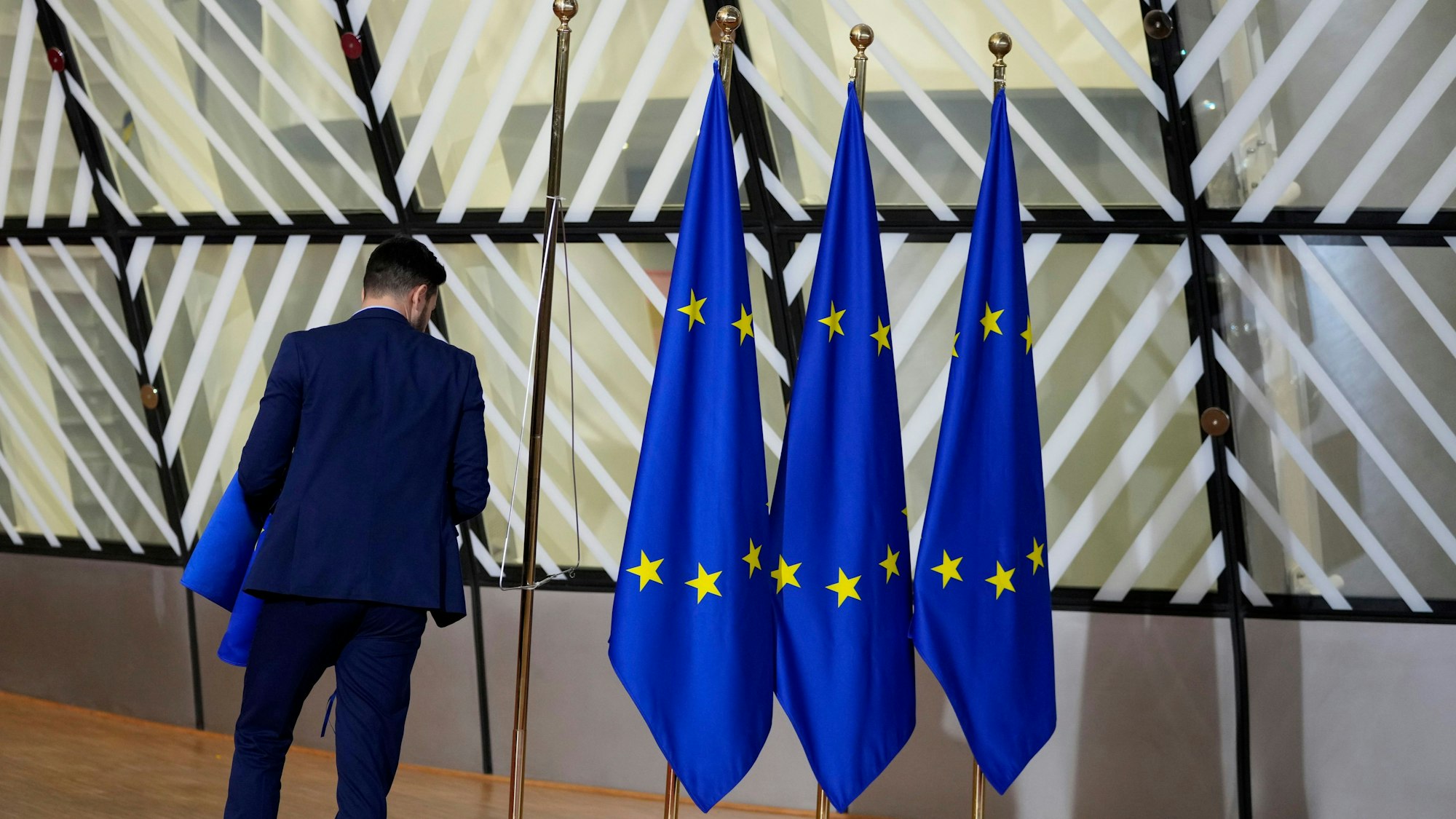 Ein Mann betrachtet drei EU-Flaggen