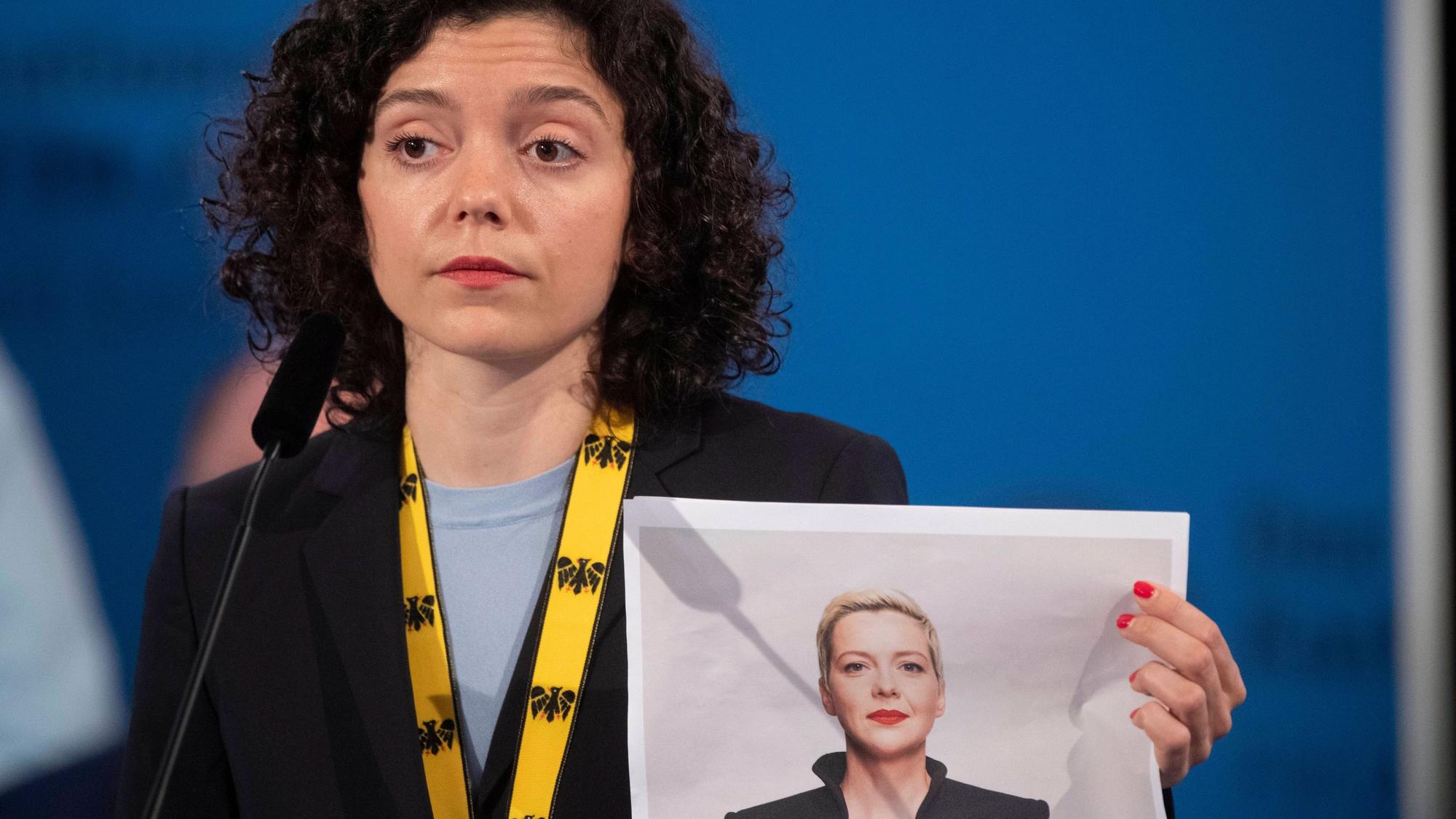 Tatsiana Khomich hält ein ausgedrucktes Foto ihrer Schwester hoch.