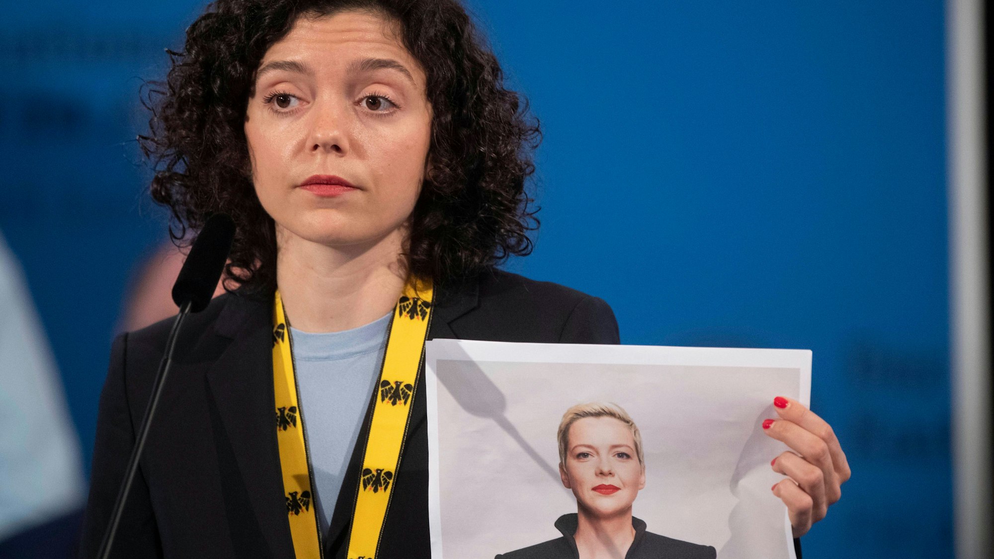 Tatsiana Khomich hält ein ausgedrucktes Foto ihrer Schwester hoch.