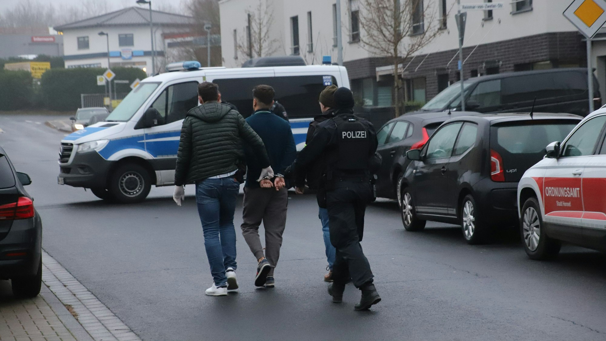 Die Polizei führt bei der Razzia in Hennef einen Verdächtigen ab.