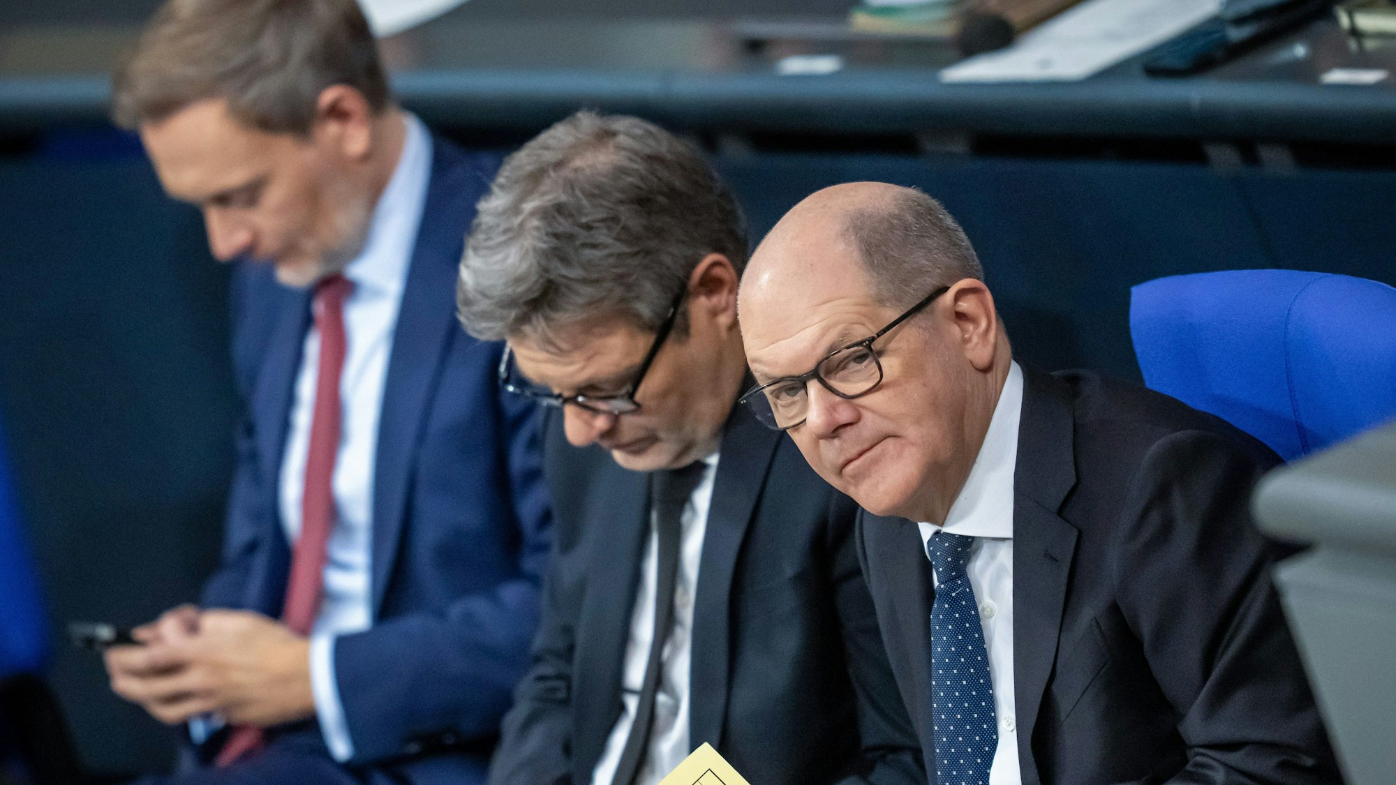 Berlin: Christian Lindner (l-r, FDP), Bundesminister der Finanzen, Robert Habeck (Bündnis 90/Die Grünen), Bundesminister für Wirtschaft und Klimaschutz, und Bundeskanzler Olaf Scholz (SPD) nehmen an der Sitzung des Bundestags mit der Regierungserklärung des Bundeskanzlers teil. In der Nacht haben sich die Ampelparteien auf einen Bundeshaushalt für das Jahr 2 2024 geeinigt.