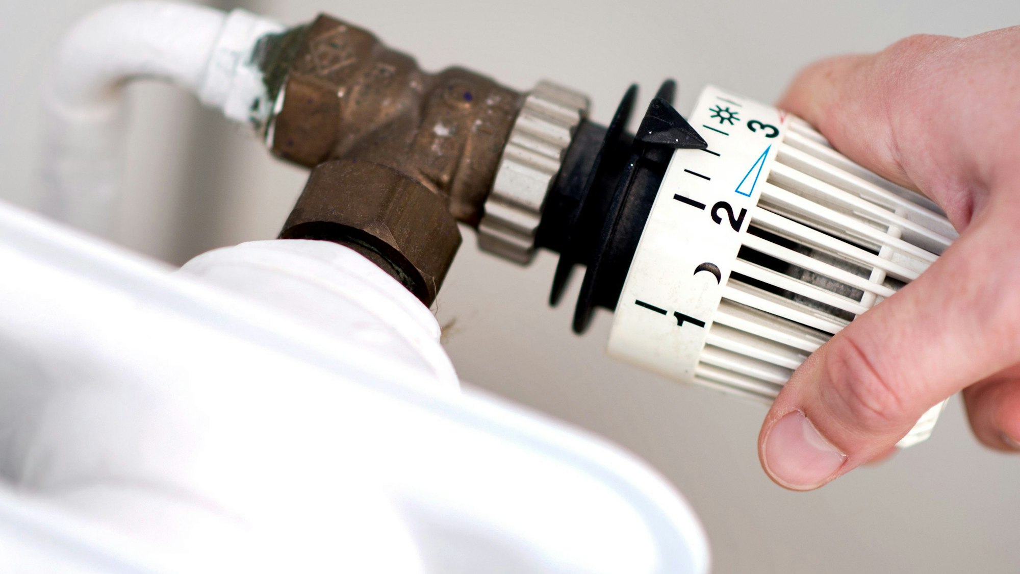 ARCHIV - 07.03.2019, Niedersachsen, Hannover: ILLUSTRATION - Eine Frau dreht am Thermostat eines Heizkörpers. (zu dpa: «Koalition will CO2-Preis beim Tanken und Heizen anheben») Foto: Hauke-Christian Dittrich/dpa +++ dpa-Bildfunk +++