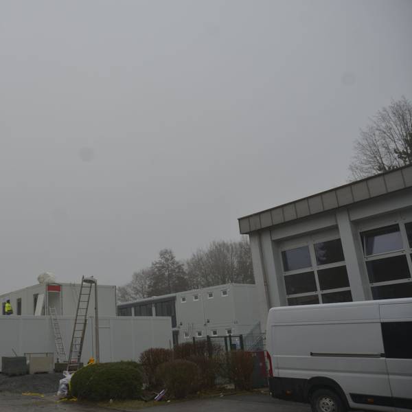 Container für die Unterbringung von Geflüchteten werden auf dem Parkplatz neben der kleinen Turnhalle an der Brionner Straße aufgebaut.