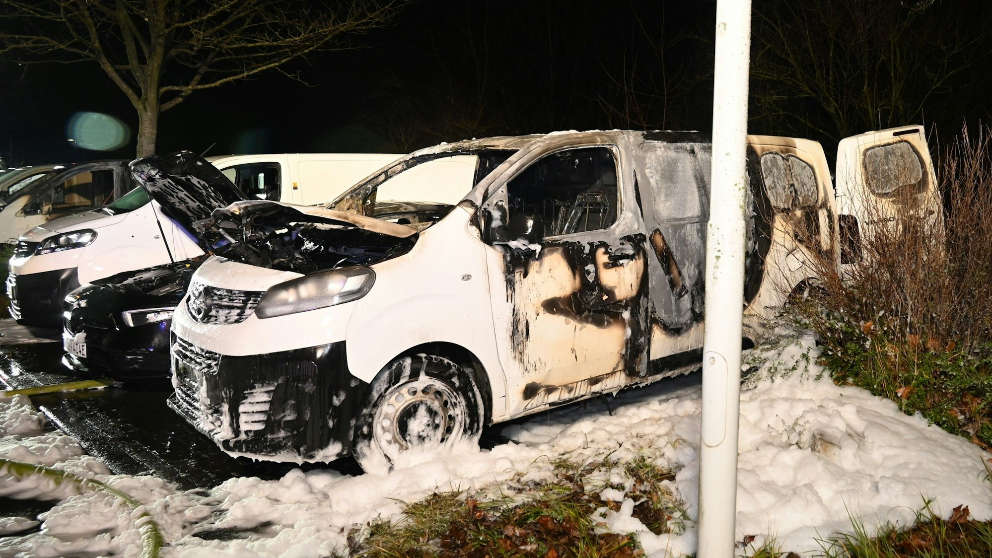 Ein weißes Fahrzeug mit Brandspuren innen und außen. Am Boden liegt Schnee.