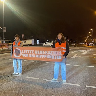Zu sehen sind fünf Aktivisten der letzten Generation bei einer Straßenblockade.