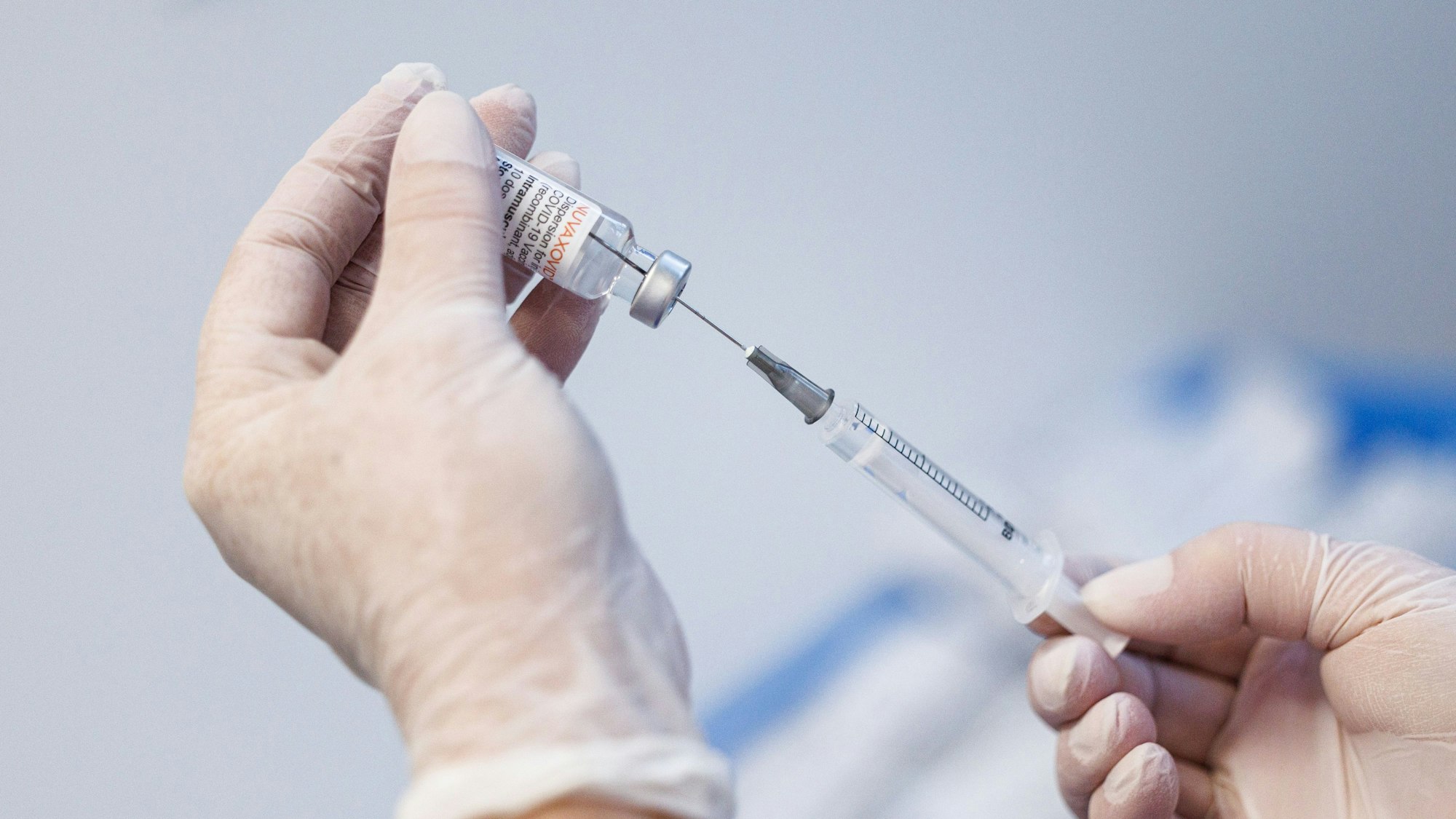 Eine Krankenschwester zieht im Impfzentrum Freising den Impfstoff Nuvaxovid vom Hersteller Novavax auf eine Spritze auf.