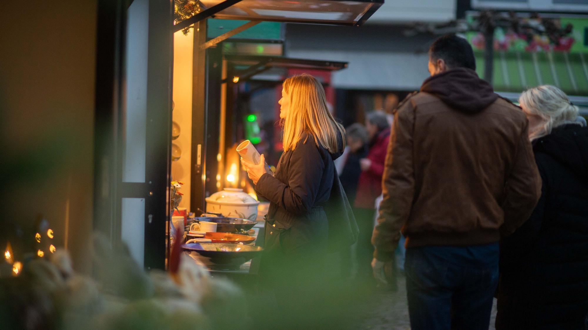 Das Bild zeigt Tanja Gille, die an einem Stand mit Steinzeugkeramik steht.
