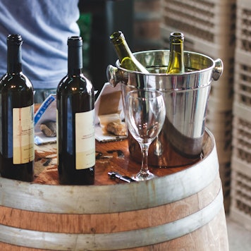 Weinflaschen auf einem Weinfass.