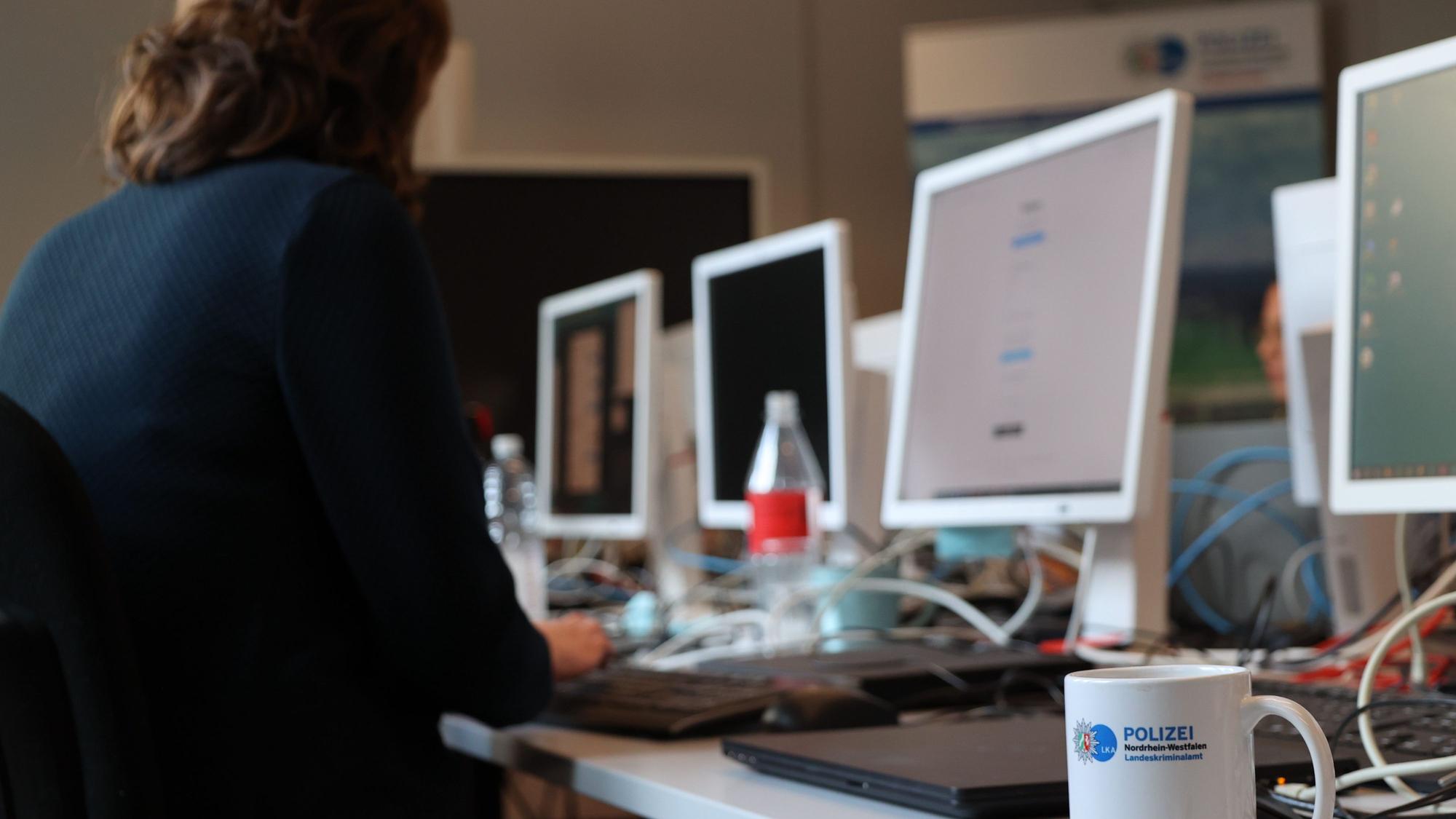 Ermittlerinnen und Ermittler des Landeskriminalamts NRW sitzen an Computern.