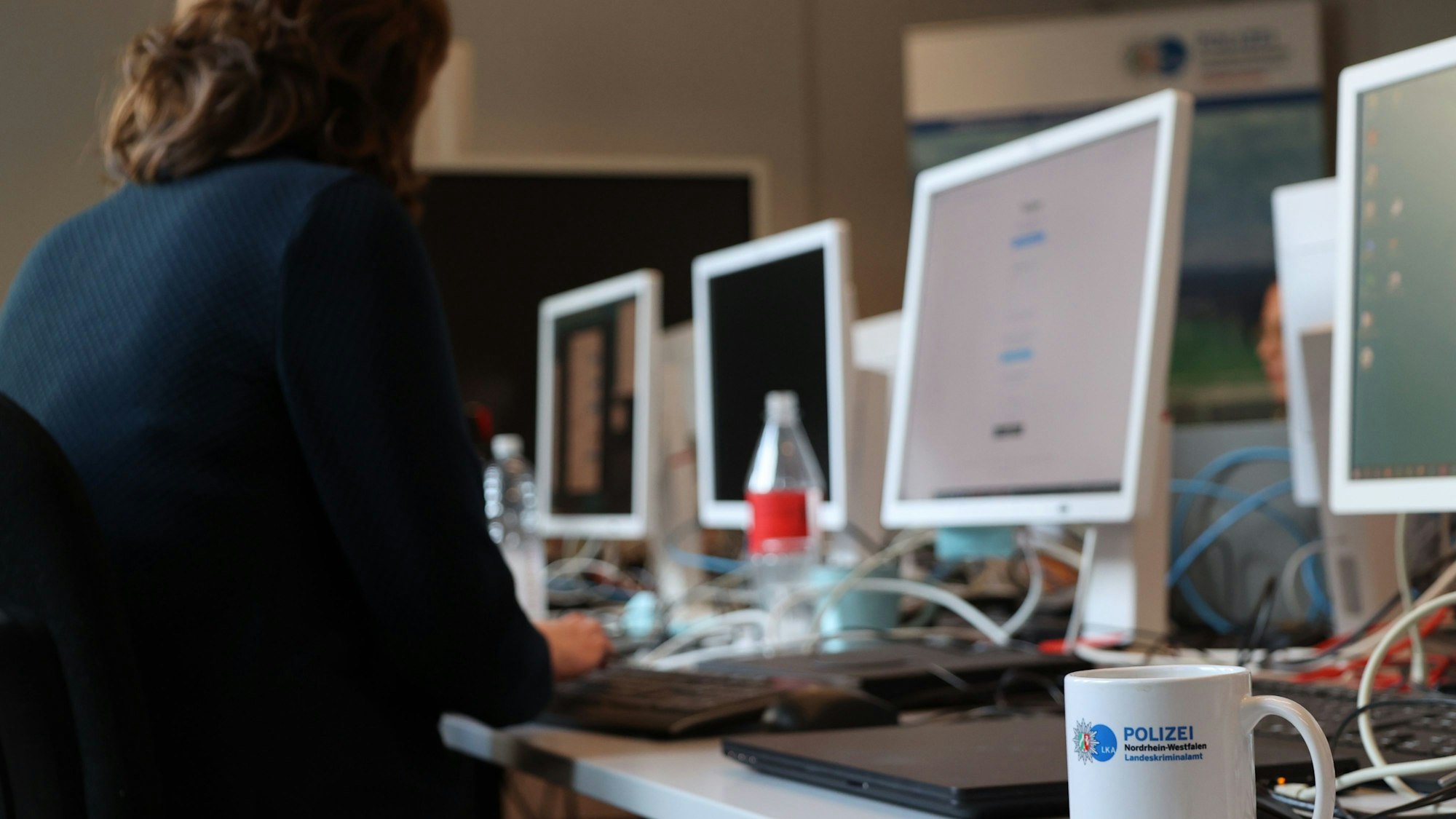 Ermittlerinnen und Ermittler des Landeskriminalamts NRW sitzen an Computern.