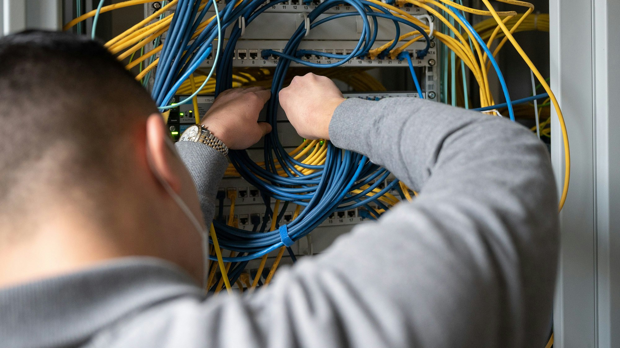 ARCHIV - 09.11.2020, Baden-Württemberg, Stuttgart: ILLUSTRATION - Ein Auszubildender Fachinformatiker Systemintegration bei der IHK Region Stuttgart im 2. Ausbildungsjahr, steckt an einem Server ein Netzwerkkabel ein. (zu dpa: "Ausbildungsmarkt erholt sich - Aber noch nicht auf Vor-Corona-Niveau") Foto: Sebastian Gollnow/dpa +++ dpa-Bildfunk +++