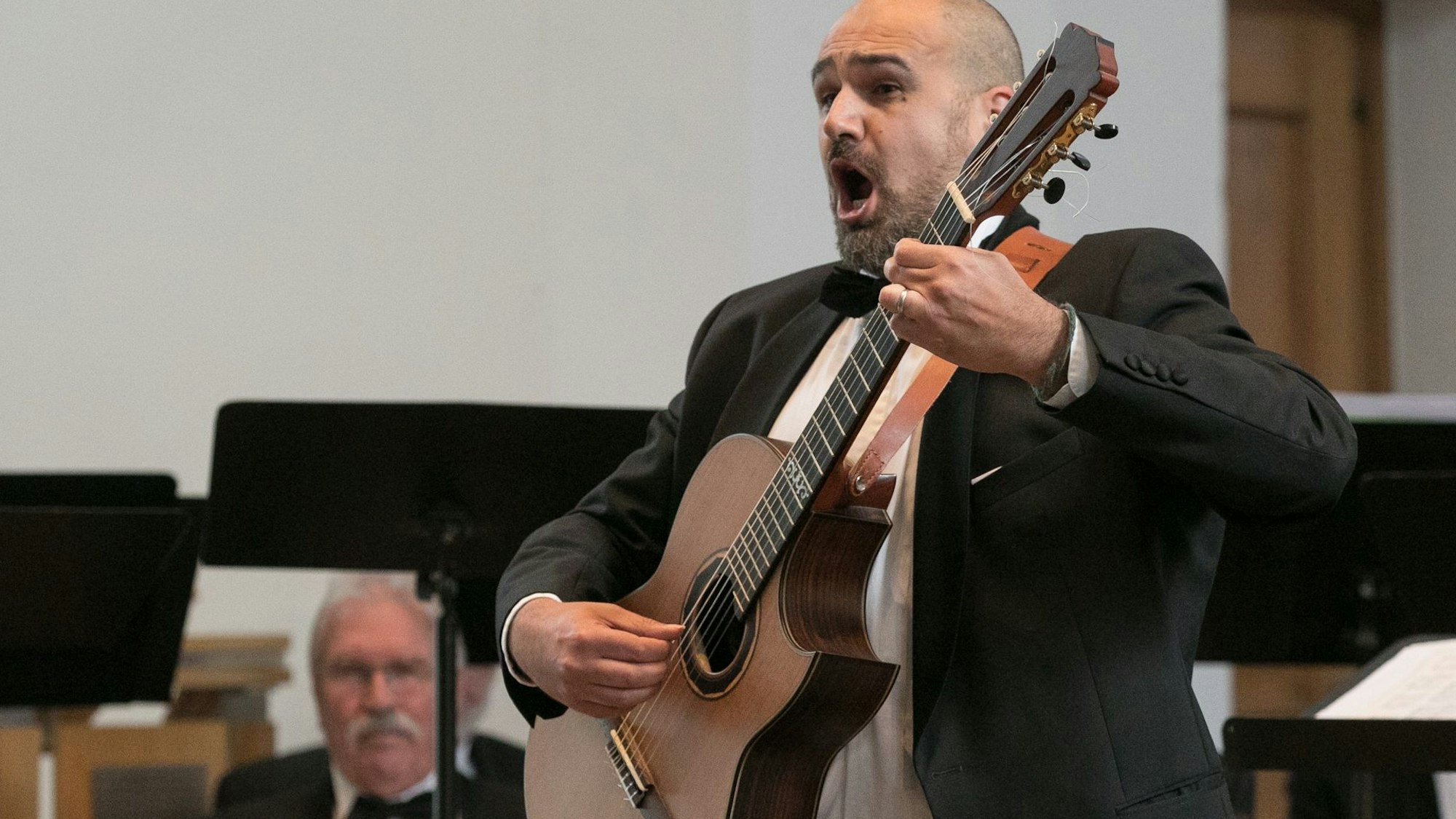 Ein Mann singt zur Gitarre.