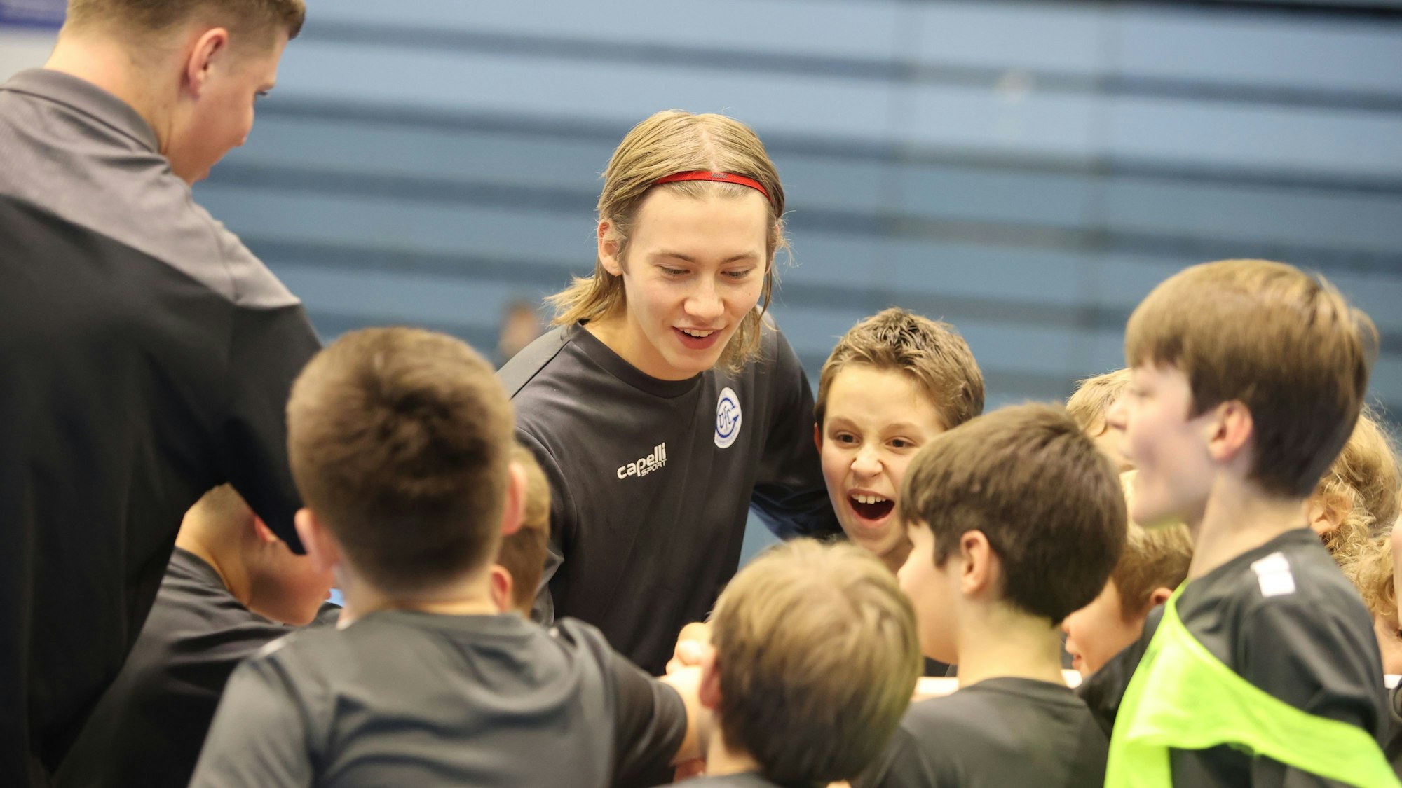 Leon Kamps erklärt als Trainer einer Gruppe Kindern etwas.
