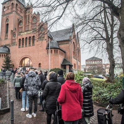 Schlange vor der Christuskirche, wo die Leverkusener Tafel die Weihnachtspakete  ausgibt.
