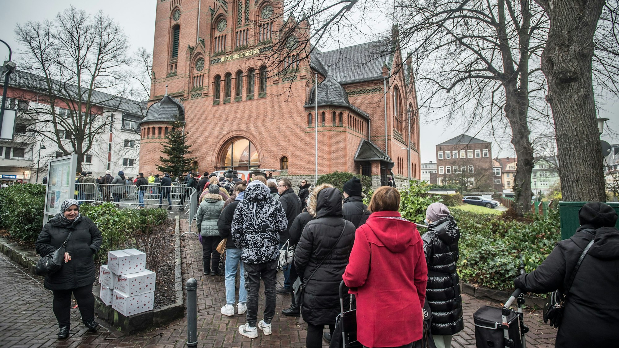 Schlange vor der Christuskirche, wo die Leverkusener Tafel die Weihnachtspakete ausgibt.