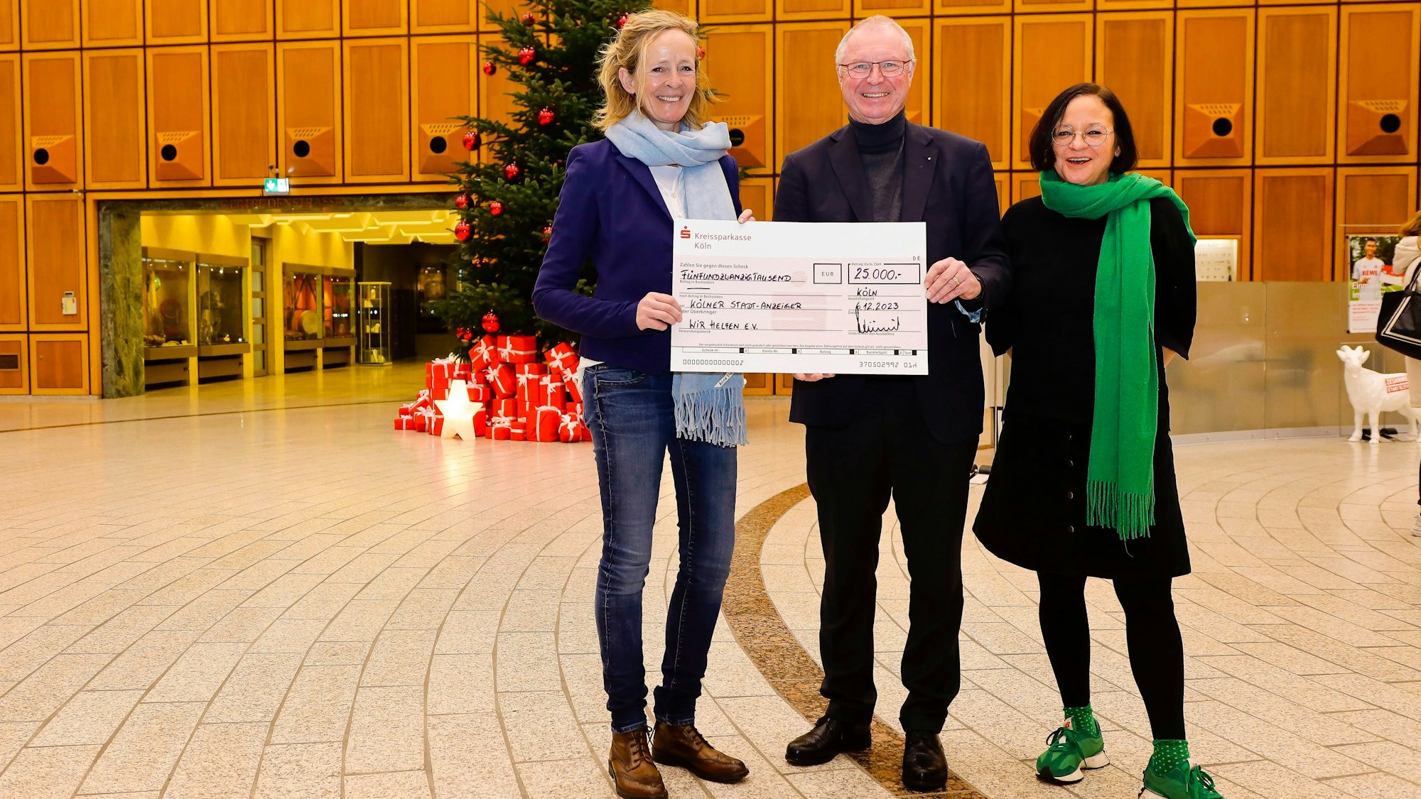 Scheckübergabe an „wir helfen“ von Alexander Wüerst (Vorstandvorsitzender der Kreisparkasse Köln) an Isabella Neven DuMont und Caroline Kron („wir helfen“) in der Schalterhalle der Kreissparkasse.