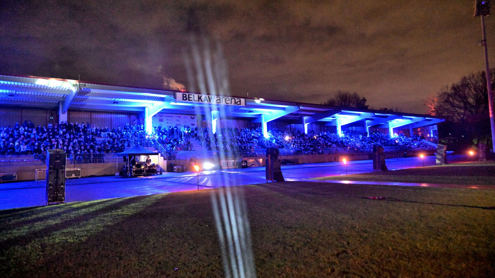 Vor dem Abendhimmel ist eine stimmungsvoll illuminierte Tribäune der Bergisch Gladbacher Belkaw-Arena zu sehen.