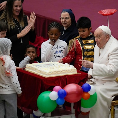 17.12.2023, Vatikan, Vatikanstadt: Papst Franziskus wird ein Kuchen angeboten, während er in der Paul VI.-Halle im Vatikan seinen Geburtstag mit Kindern feiert, die von der Santa Marta Krankenstation unterstützt werden. Papst Franziskus wird am 17. Dezember 87 Jahre alt. Foto: Alessandra Tarantino/AP/dpa +++ dpa-Bildfunk +++