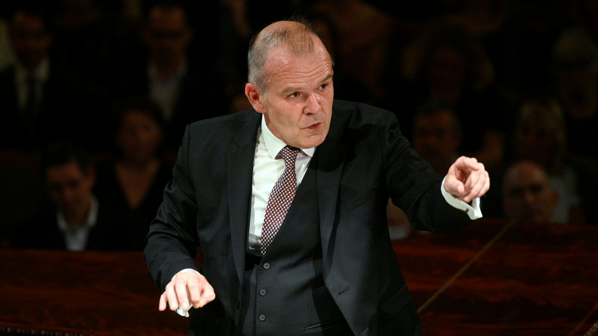 François-Xavier Roth dirigiert im dreiteiligen Anzug mit Krawatte.