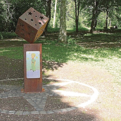 Auf dem Friedhof in Blankenheim steht eine Stele auf einer Rasenfläche. Darauf ist ein Abbild des kleinen Prinzen.
