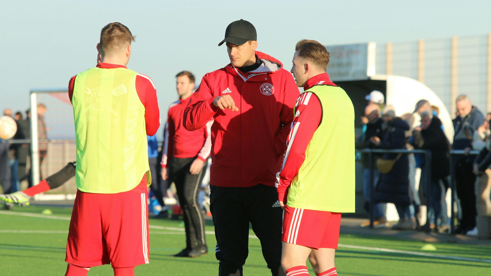 Zülpichs Trainer David Sasse gibt zwei Ersatzspielern Anweisungen.