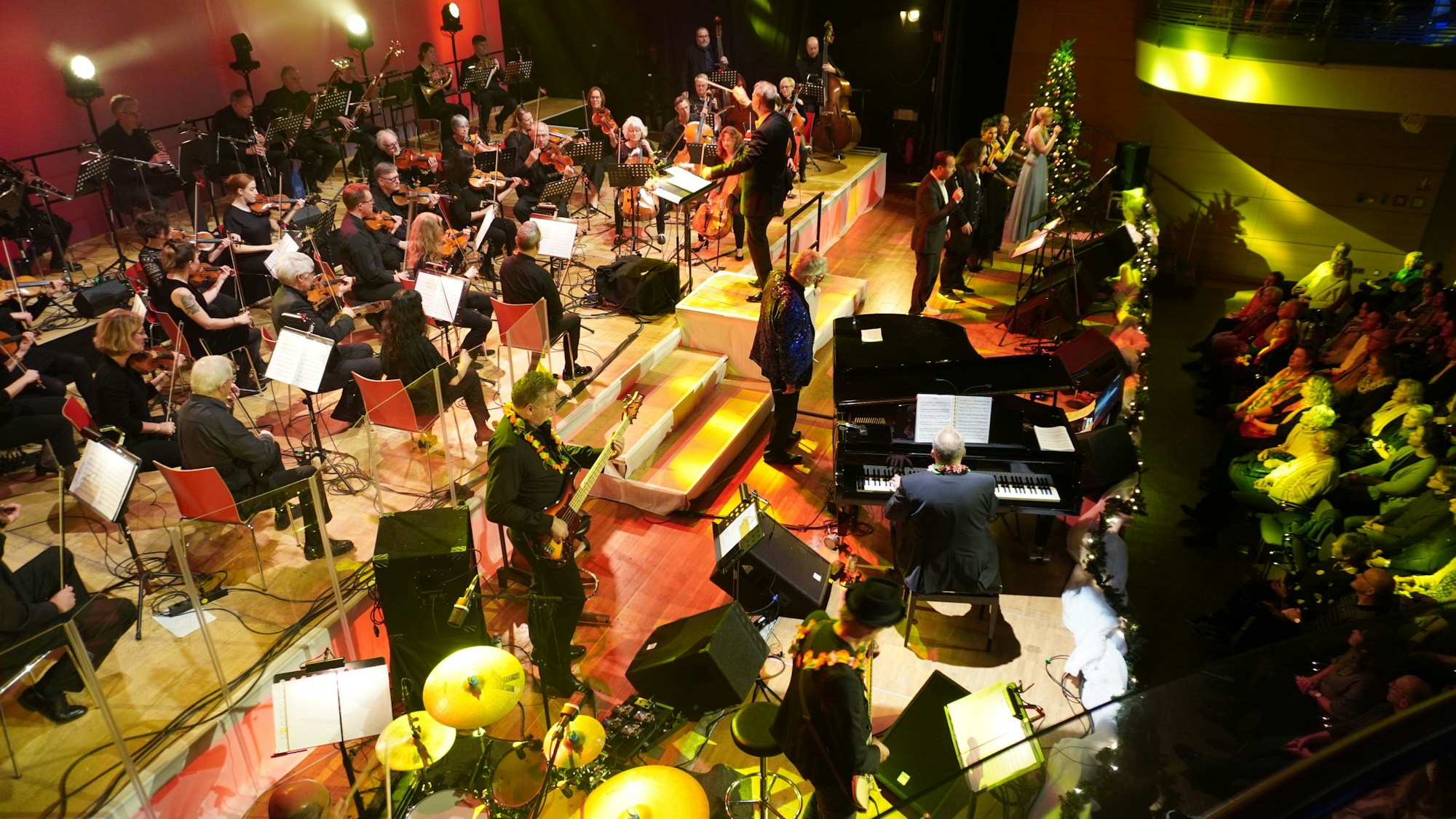 Eine Bühne mit klassischen Orchestermusikern und  einer Band.