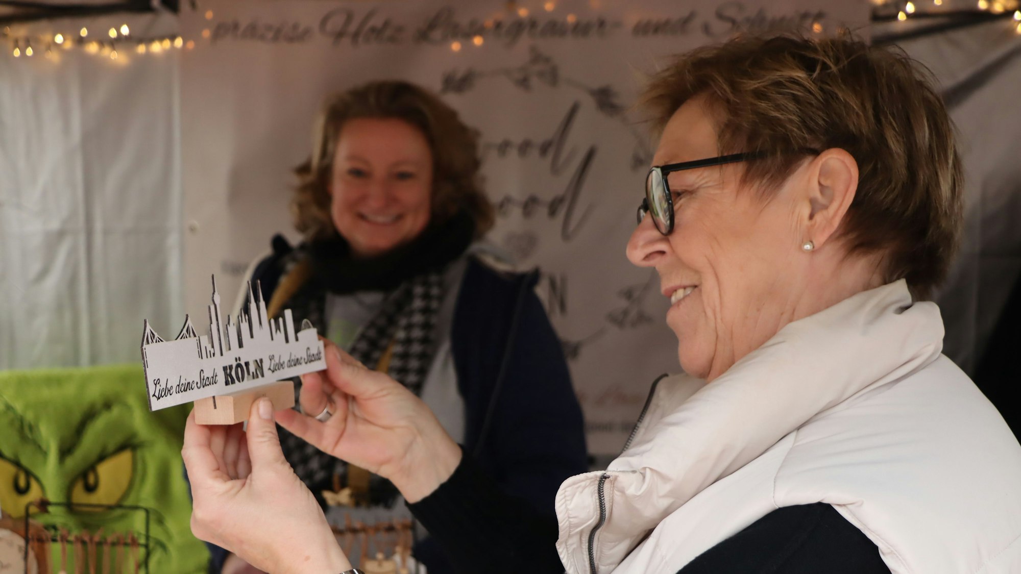 Das Bild zeigt Beate Kraus mit einem Holzschnitt vom Köln-Panorama, den Nicole Meinke aus Elsdorf angefertigt hat.