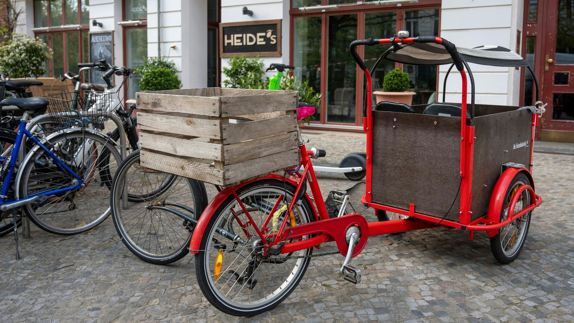 Ein Lastenfahrrad steht vor einem Café.