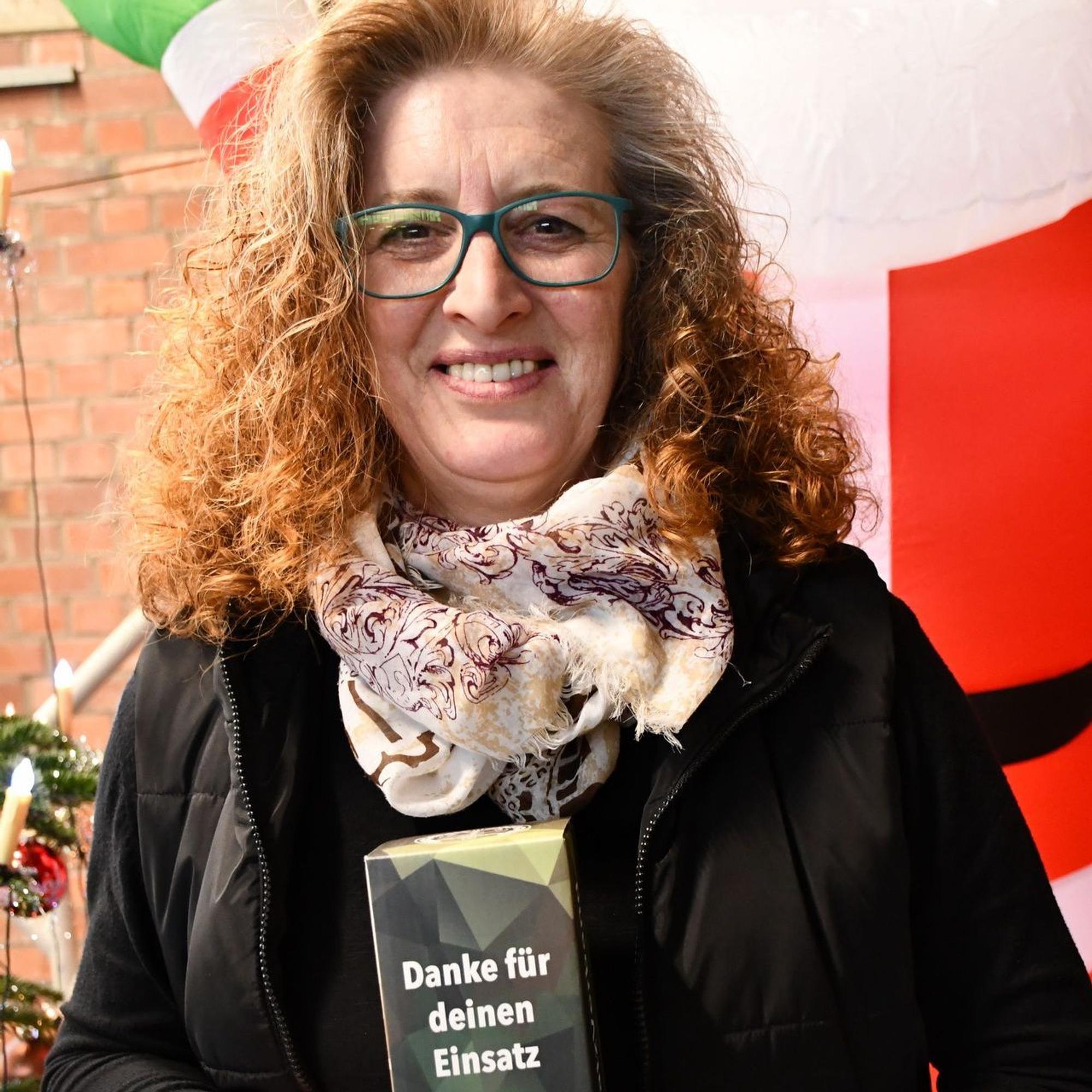Heidi Piel hält ein Weihnachtspäckchen in den Händen, das im Bundeswehr-Tarn daherkommt.
