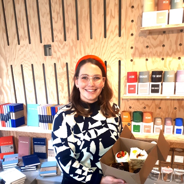 Eine junge Frau hält Kuchen in der Hand.