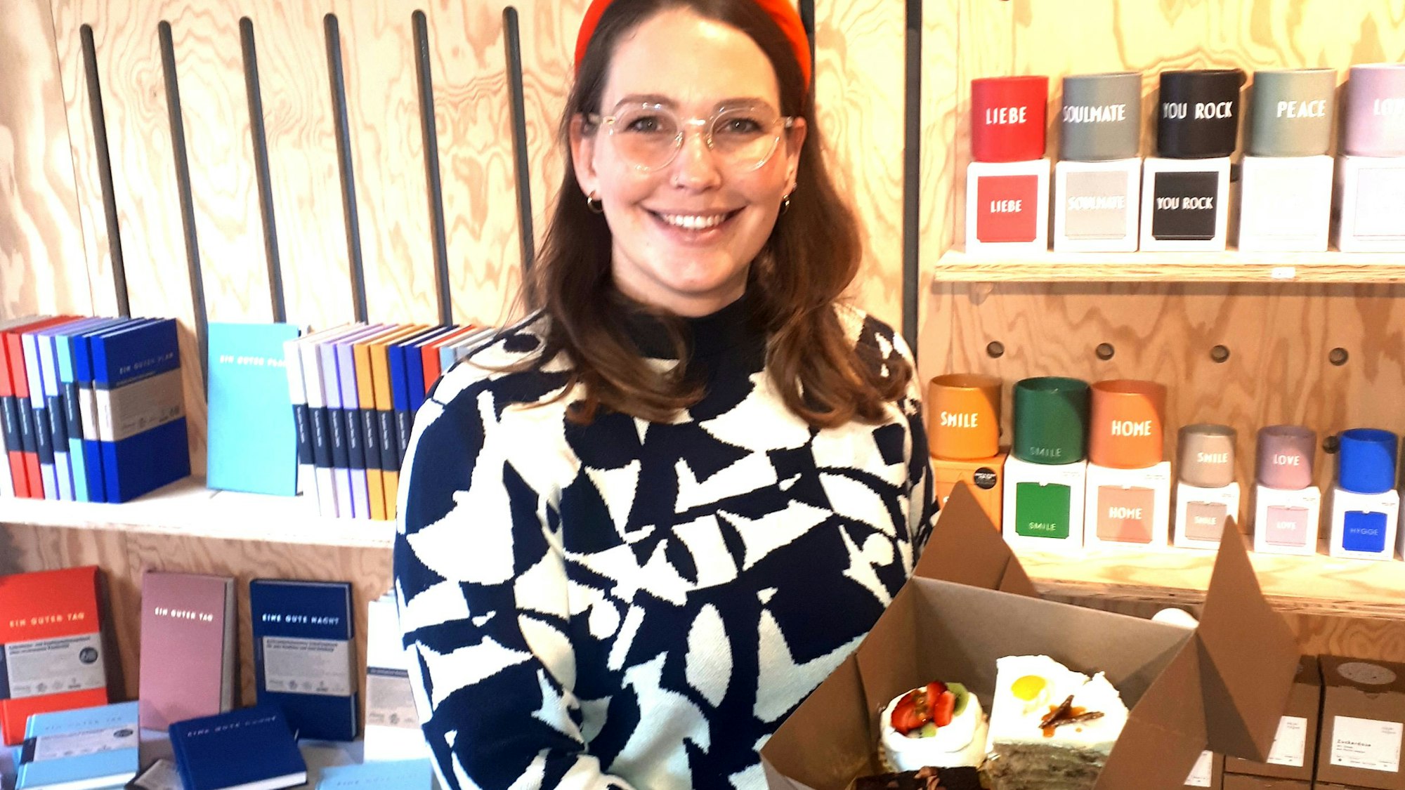 Eine junge Frau hält Kuchen in der Hand.