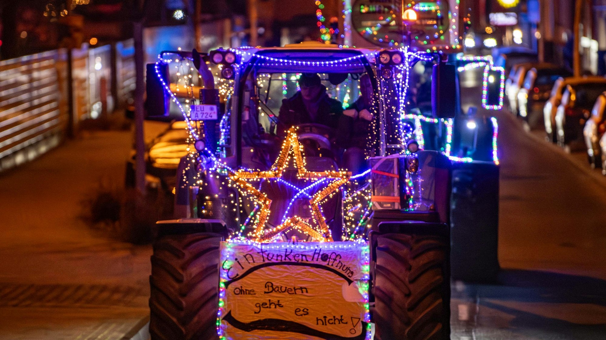 Ein mit Lichterketten und einem leuchtenden Stern geschmückter Traktor bei einer Lichterfahrt von Landwirten im Jahr 2023 im Kreis Euskirchen.