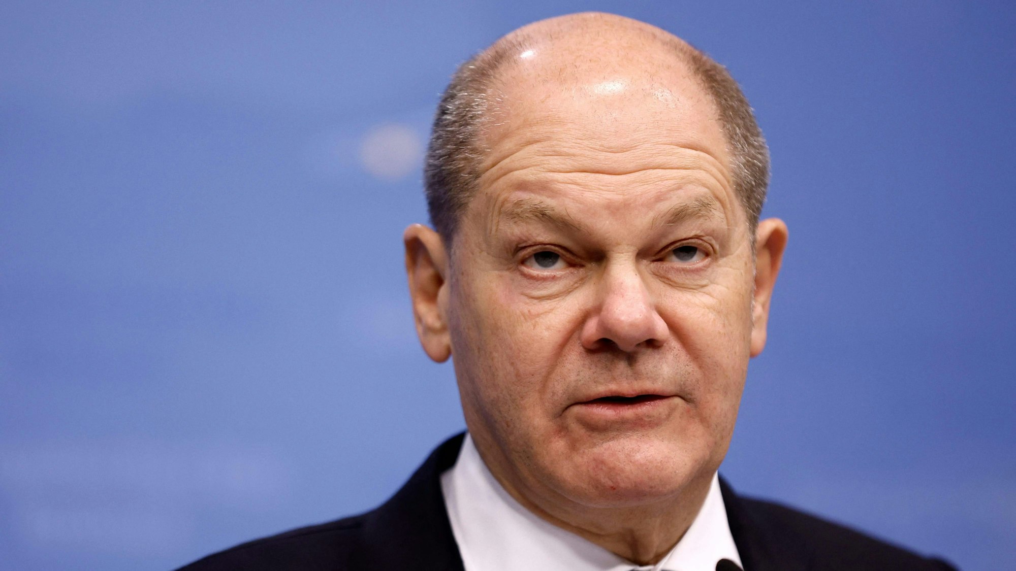 Nahaufnahme von Olaf Scholz Kopf. Der Bundeskanzler schaut nach oben.