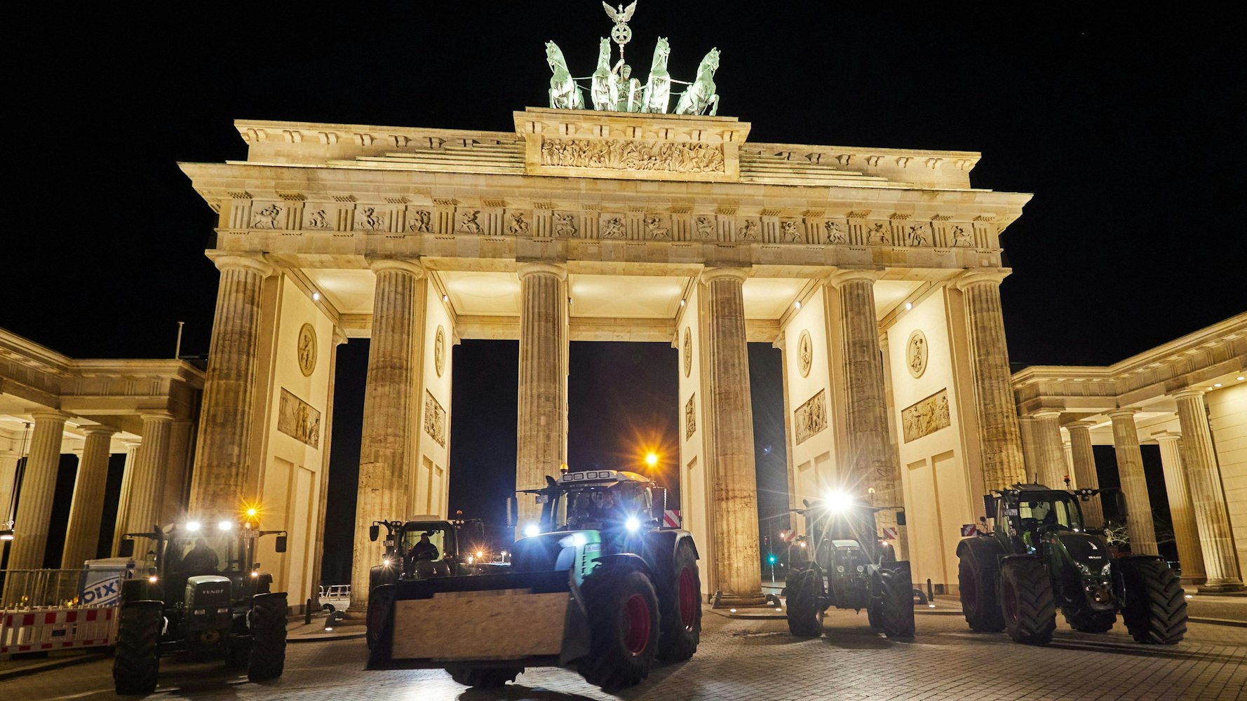Landwirte aus Ostholstein stehen mit ihren Traktoren vor dem Brandenburger Tor.
