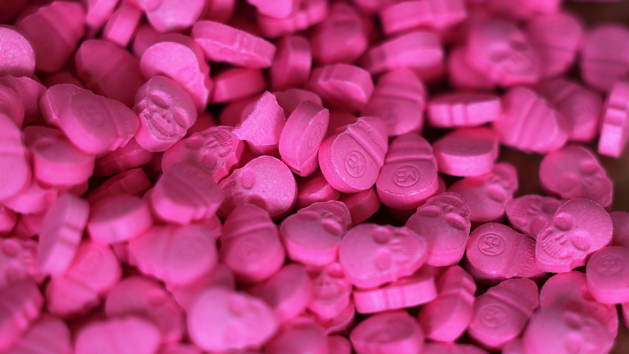 Ecstasy-Tabletten in Form von Totenköpfen liegen in einem Zollamt auf einem Tisch.