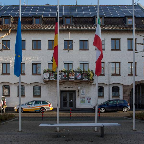 Autos parken in der Abendsonne vor dem Zülpicher Rathaus.