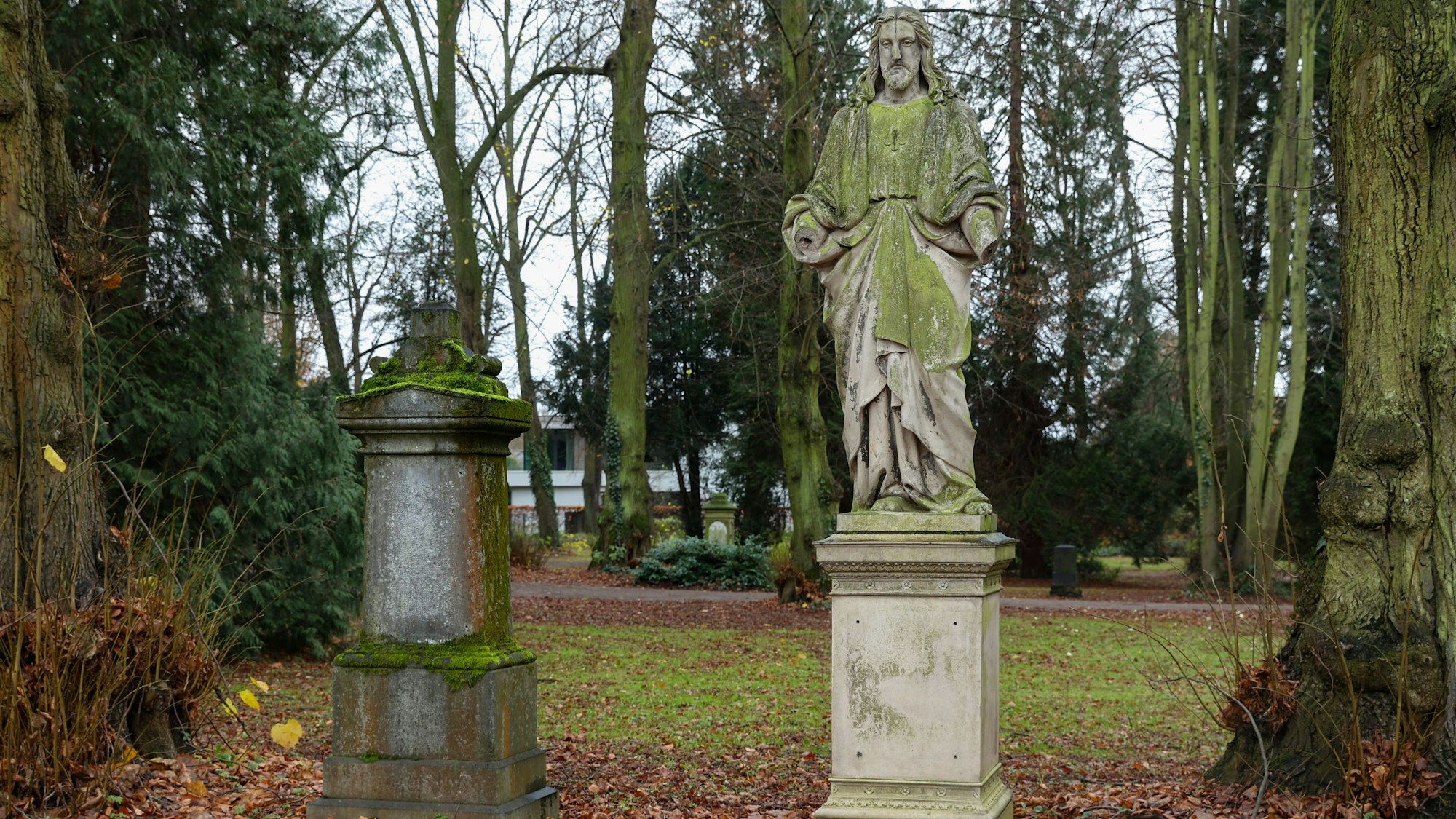 Eine Statue und ein Grabstein auf dem Friedof in Deckstein. Die Einweihung des Friedhofs erfolgte zwar erst am 2. Mai 1869, doch wurde der Friedhof nur bis zu Beginn des 20. Jahrhunderts genutzt.