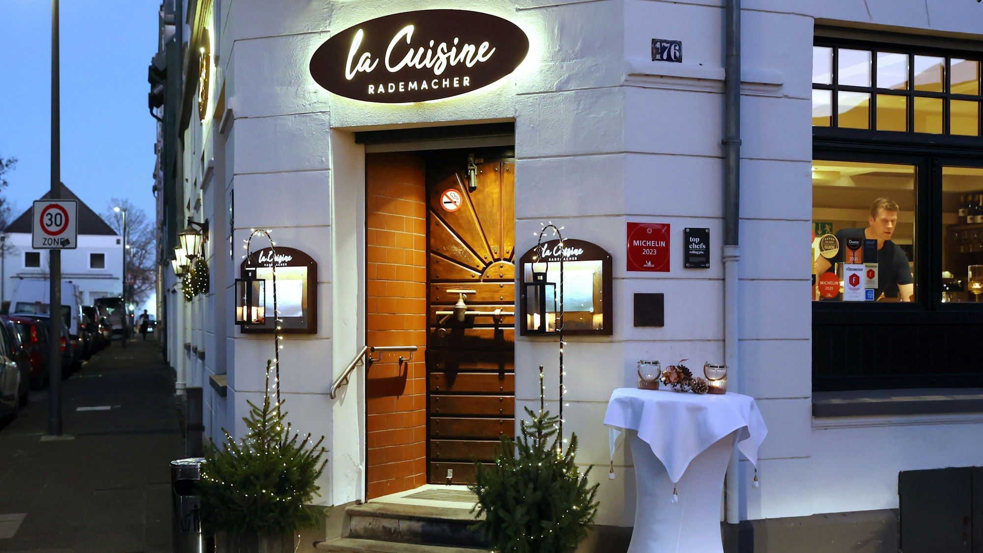 Der Eingang des La Cuisine Rademacher dezent geschmückt mit zwei Weihnachtsbäumen.