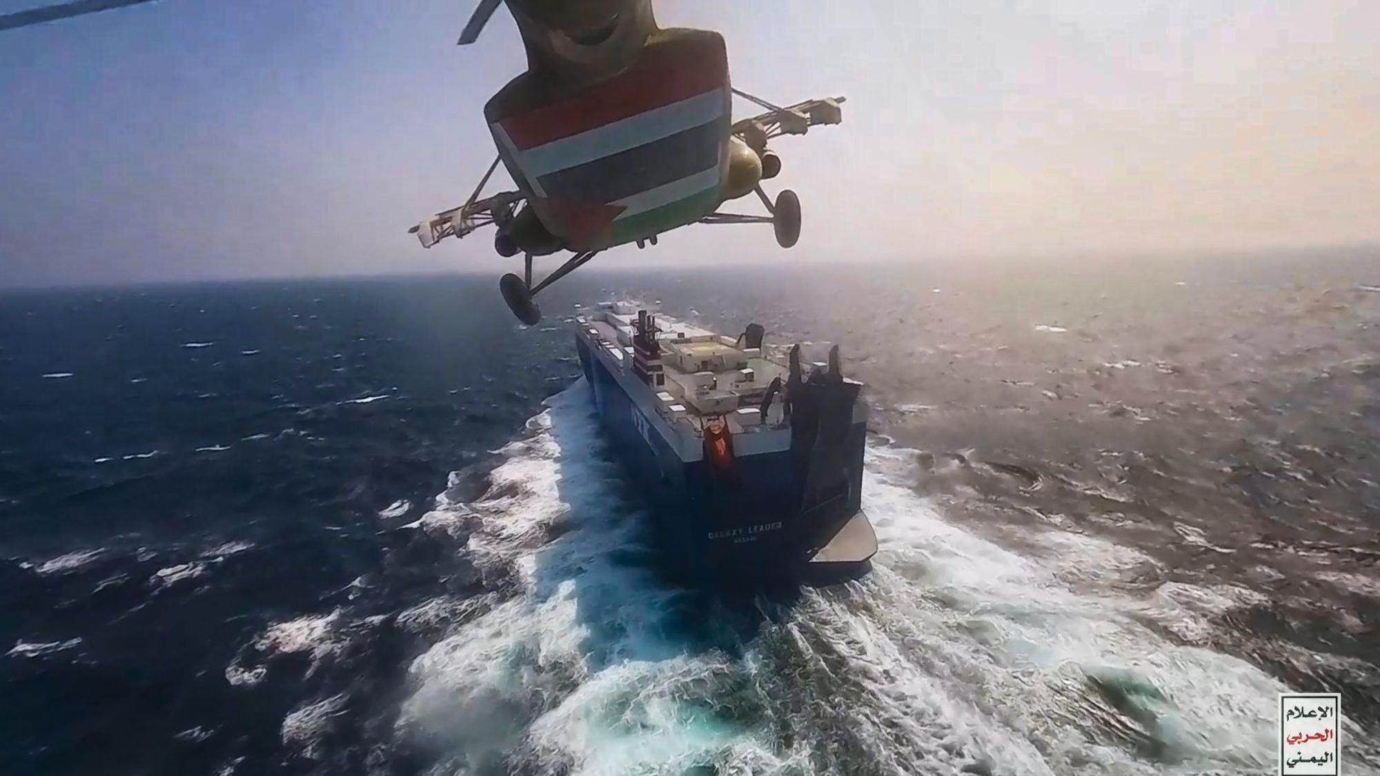 Ein Handout-Foto, das am 21. November 2023 vom militärischen Medienzentrum der Huthi zur Verfügung gestellt wurde, zeigt einen Huthi-Hubschrauber, der über das Frachtschiff „Galaxy Leader“ fliegt, als sie es im Roten Meer vor der Küste von Hodeidah in ihre Gewalt bringen.