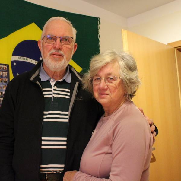 Krista und Walter Feckinghaus stehen vor einer Brasilien-Flagge in seinem Arbeitszimmer in Oberwichterich.