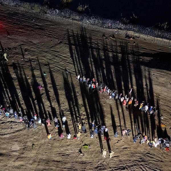 Migranten, die den Rio Grande von Mexiko aus überquert haben, stehen vor dem Aufnahmezentrum in Eagle Pass in Texas Schlange.